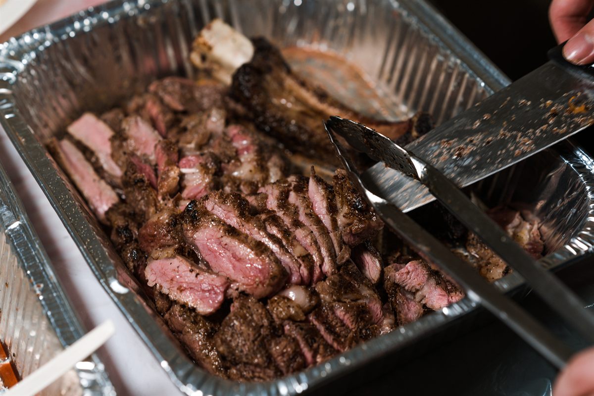 Sliced grilled beef being served at a Sunday Roast BBQ event