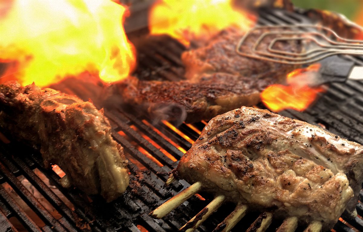 Premium beef and lamb cuts grilling over live fire for the Premium menu